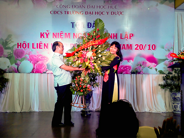 GS.TS Võ Tam, Phó Bí thư Đảng ủy, Phó hiệu trưởng trao tặng lẵng hoa của Đảng ủy, Ban Giám hiệu Trường cho nữ CBVC Trường